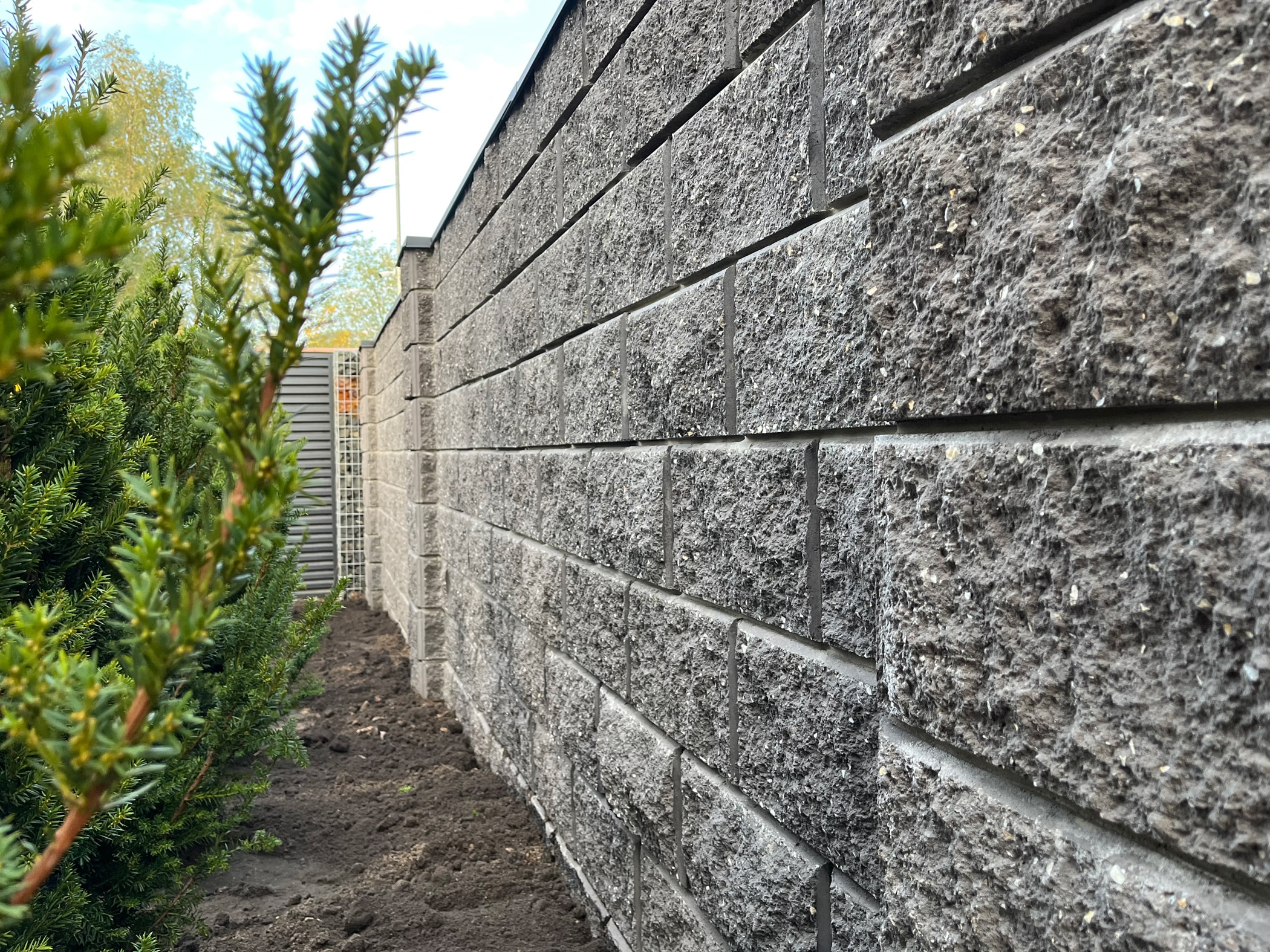 Сірий паркан з бетонних декоративних блоків 